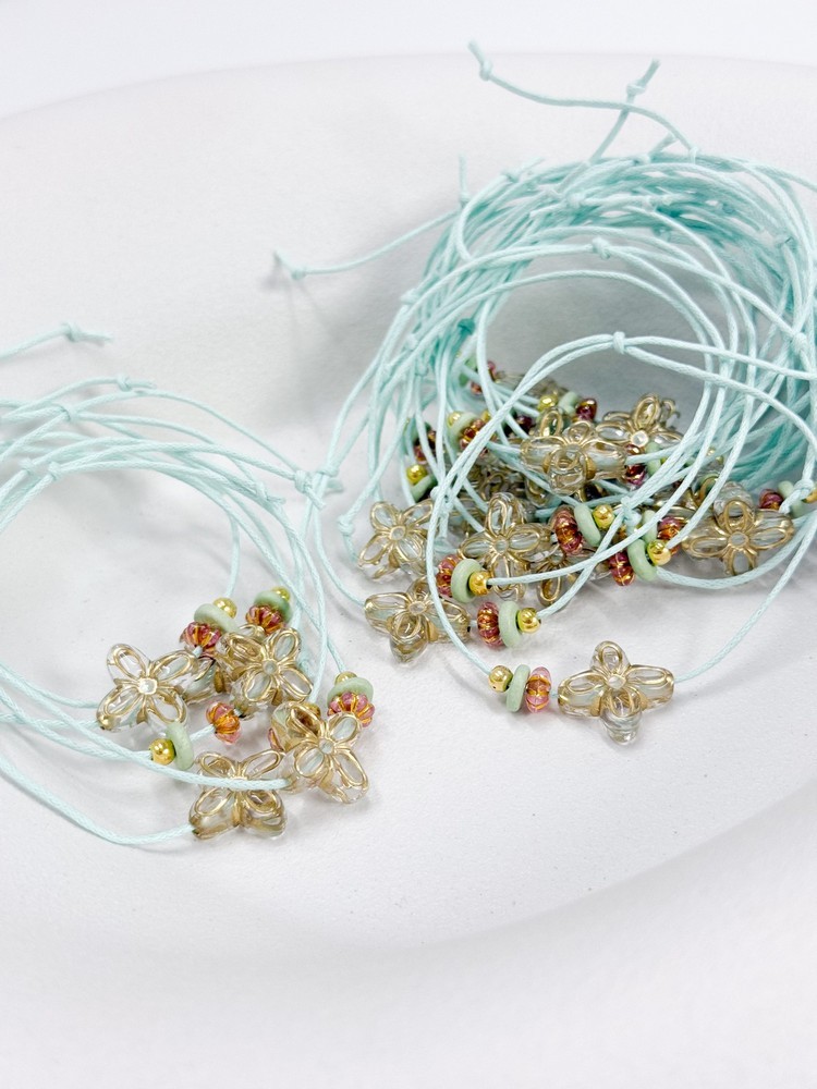 Μαρτυρικό βραχιόλι με ακρυλικό σταυρό σε σχήμα λουλούδι, χάντρες και κερωμένο κορδόνι R46 (50τμχ)